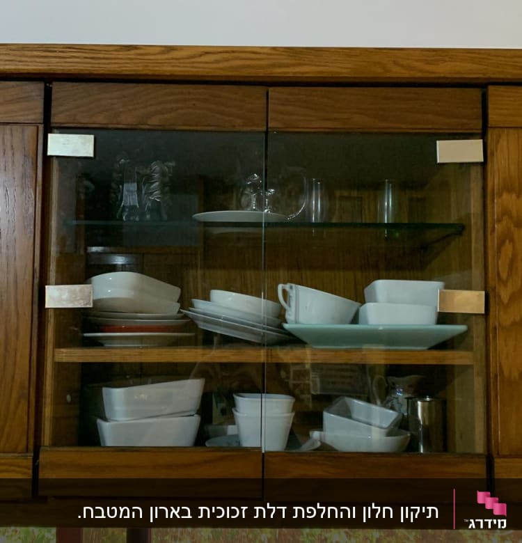 ארון עם דלתות זכוכית וכלי מטבח בפנים